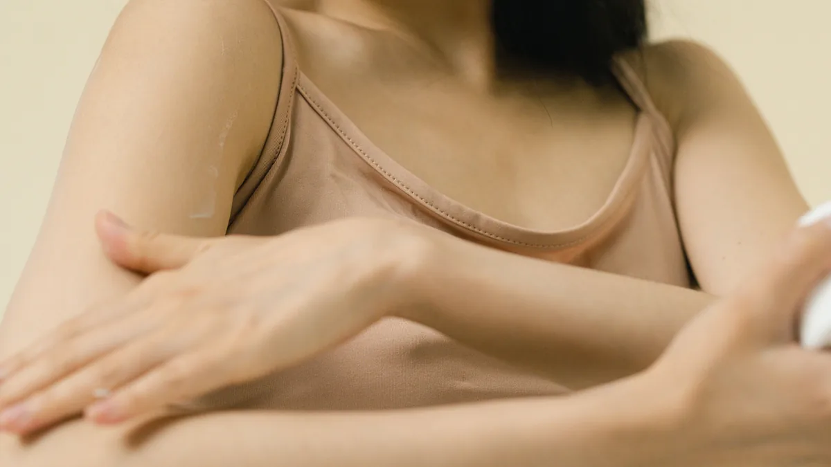A woman smoothing cream along her forearm